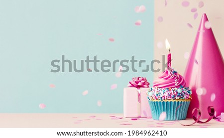 Birthday background with pink birthday cupcake and candle, birthday gift and party hat