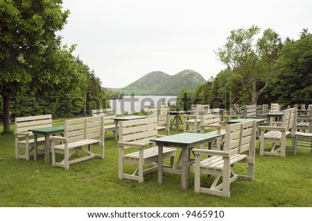 outdoor dining area overlooking jordan pond in front of the bubble mountains