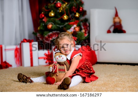 Happy dreaming child holding Christmas decoration under the Christmas tree