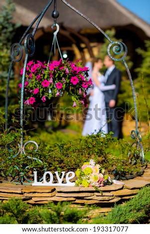 Wedding flowers bouquet with wedding couple wife and groom on background outside