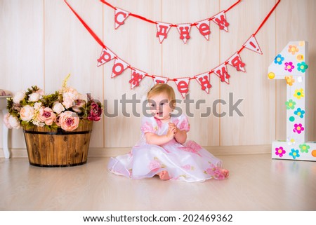 Little girl child celebrate first Happy Birthday Party in pink dress with  decor in the beautiful room
