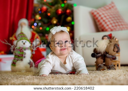 New Year\'s Concept. Adorable little girl near a Christmas tree with presents laughs. new year