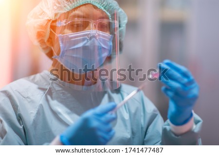 Similar – Image, Stock Photo Young researcher with protective goggles checking test tubes