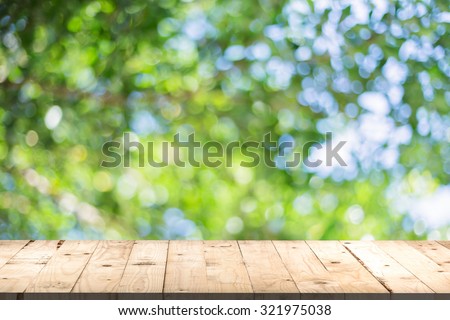 wood table perspective and green leaf bokeh blurred for natural background