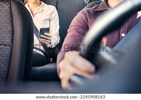 Phone in car or taxi. Passenger woman using cellphone in back seat of cab. Driver and customer. Rideshare mobile app. Professional business person travel to work, commute. Lady sitting in the backseat Stock foto © 