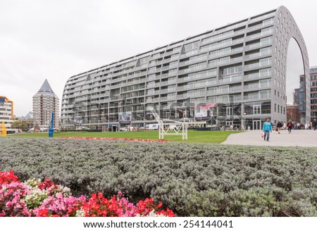 ROTTERDAM, THE NETHERLANDS - October 8, 2014: exterior of new Market Hall on October 8, 2014 in Rotterdam, The Netherlands. Inside are food shops, the shell are apartments; people walk to shop.