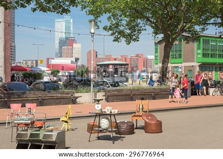 ROTTERDAM, THE NETHERLANDS â?? JULY 11, 2015: People enter a flea market on a beautiful summer day on July 11, 2015 in Rotterdam, The Netherlands; on the background stands the downtown skyscrapers.