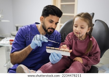 Similar – Image, Stock Photo Young bearded male dentist drilling tooth to female patient