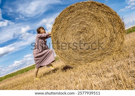 Similar – Image, Stock Photo Woman Pushing Hay Bale