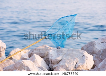 An old fishing net hanging on stones