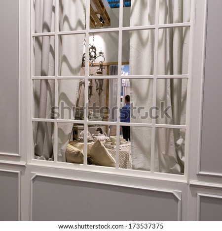 PARIS, FRANCE - JANUARY 24, 2014: People visit a stand behind a window at Maison&Objet, the French leading professional trade show for home fashion in Paris, France.