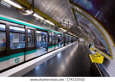 PARIS, FRANCE - CIRCA JANUARY, 2014: People board a train in the Paris metro. Traffic for the Paris metro is over 2 billion rides per year.