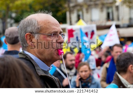 PARIS, FRANCE - OCT. 5, 2014: A man uses a pink whistle during an anti-gay rights protest in Paris. The manifestation drew around 100,000 people that day.
