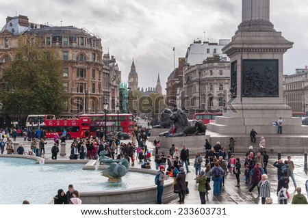 LONDON, UNITED KINGDOM - NOVEMBER 8, 2014: Tourists visit Trafalgar Square on a cloudy day. It is one of the most popular tourist attraction in London, often considered the heart of London.