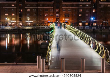 LONDON, UNITED KINGDOM - NOVEMBER 10, 2014: Illuminated foot bridge in over North Dock in Canary Wharf by night