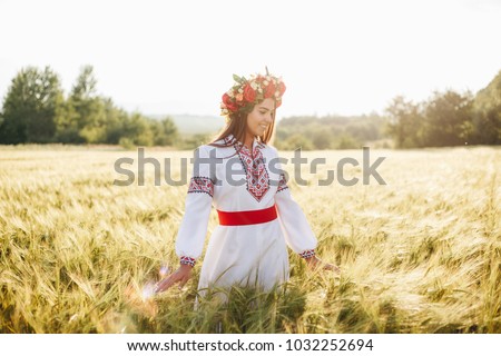 Foto Bild Lächelnde ukrainische Frau mit Nationalflagge auf Himmel Hintergrund. Porträt der jungen Dame in blauer Stickerei vyshyvanka. Kopieren Raum. Ukraine, Unabhängigkeit, Freiheit, patriotisches Symbol, Sieg im Krieg.