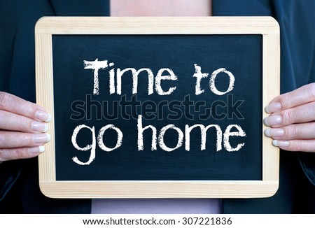Time to go home - woman holding chalkboard with text