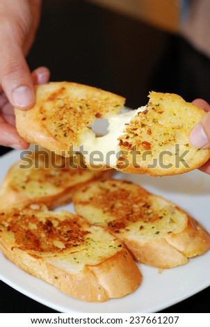 tearing garlic bread with cheese inside