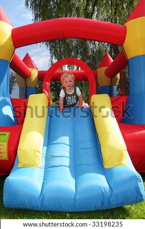 child on bouncy castle. inflatable blow-up toy for kid in garden