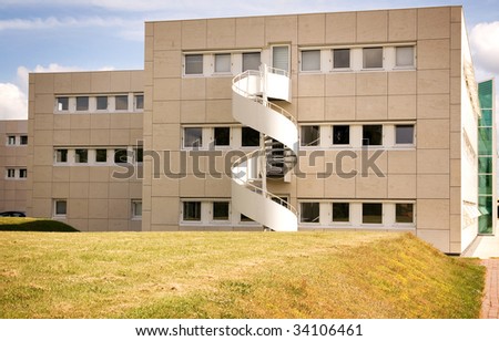 office building facade in concrete blocks. architecture with fire escape stairs