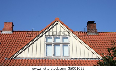 roof loft conversion or dormer. tiled house with chimneys and windows against blue sky