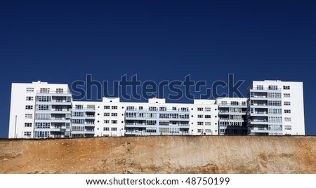 holiday apartments or hotel on top of cliffs in brighton, england. flats with balcony against blue sky