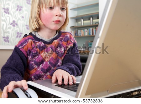 Child playing with computer. Blonde boy typing or working on laptop keyboard. kid concentrating on pc