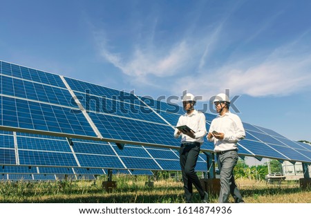 The solar farm(solar panel) with two engineers walk to check the operation of the system, Alternative energy to conserve the world's energy, Photovoltaic module idea for clean energy production. Сток-фото © 
