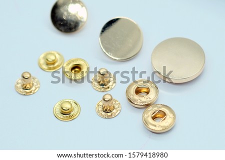 Metal gold button for clothes. Sewing accessories for outerwear production. Components of the press-stud with a flat top on a white background close-up. ストックフォト © 