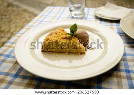 Prague piece of apple cake with ice cream on white plate.