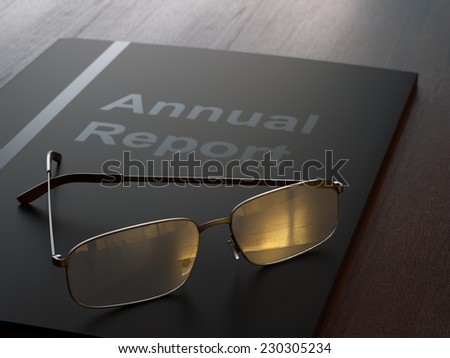 Black annual report folder and glasses on dark wood table close-up