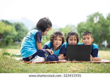 boy and girl with notebook on the grass