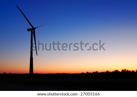 Wind turbine against an evening glow background