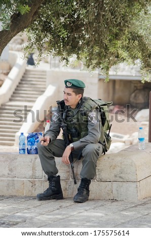 JERUSALEM - OCT 4:  Israeli police man in uniform sitting on the parapet in Jerusalem , October 4, 2013.