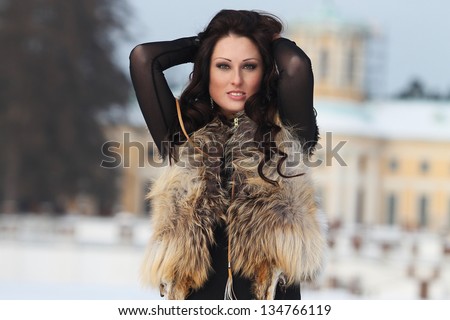 Woman in fur jacket walking in winter park