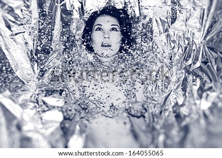 Beautiful young woman dressed silver clothes in snow. Enjoy of winter. Christmas