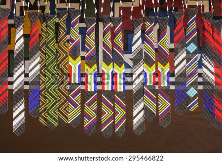 African unique traditional handmade colorful beads ties. Flag of South Africa. Local craft market.