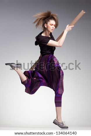 sexy woman model jumping in large pants - studio fashion shot