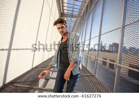 Handsome fashion male model dressed casual in a grungy location, wide and dynamic shots