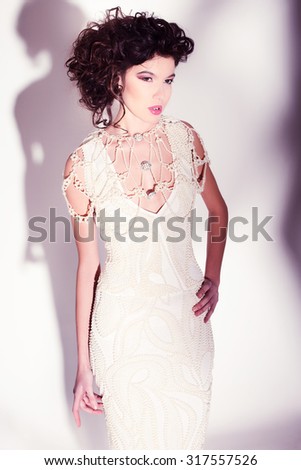 beautiful woman model posing in elegant pearl dress in the studio