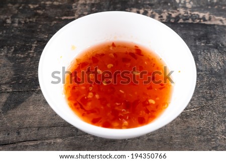sweet chilli dipping sauce  with white cup paste on wooden table