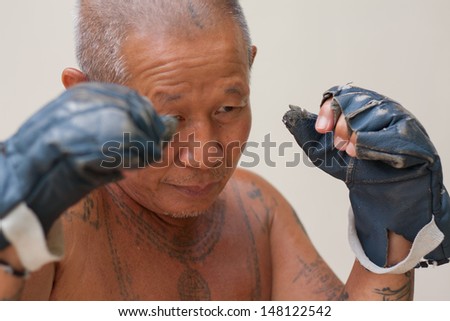 Asian boxer staying in guard, his body full of tattoo