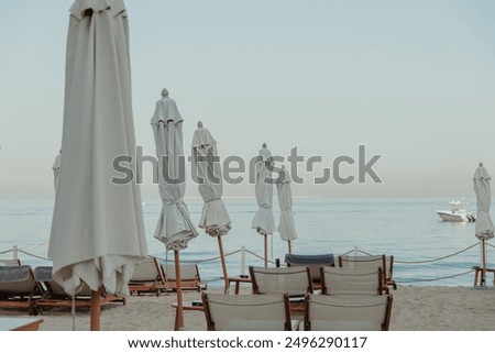 Similar – Image, Stock Photo Closed umbrellas at a beach bar in Valencia in wintertime