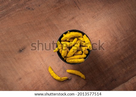 dried or dry turmeric curcuma or halkund or whole turmeric fingers o r sticks in a bowl on wooden background dark theme Foto stock © 
