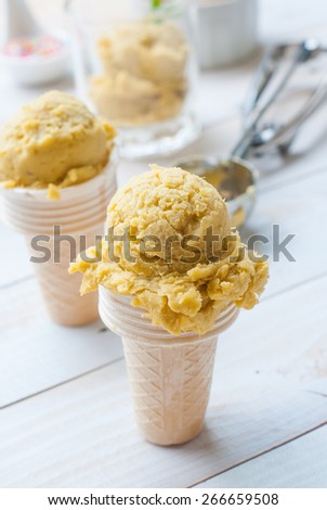 Homemade mango ice cream on vintage light white wooden background
