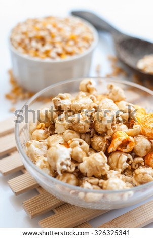A bowl of popcorn on a wooden table, caramel popcorn