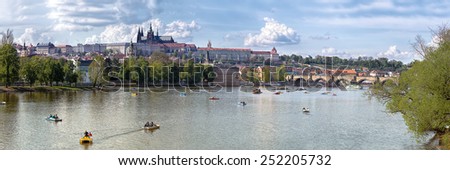 Prague, Czech Republic - April 20, 2014: tourists from around the world and the citizens enjoying spring and river activities in the most famous location in Prague, Prague Castle and Charles Bridge
