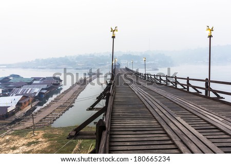 The ancient broken Mon bridge in Sangkhlaburi District, Thailand, in misty morning  and a temporary wooden bridge below.