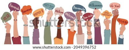 Raised arms and hands of multi-ethnic people from different nations and continents holding speech bubbles with text -Welcome- in various international languages.Communication. Community