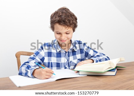 A handsome teenage boy is doing his homework.